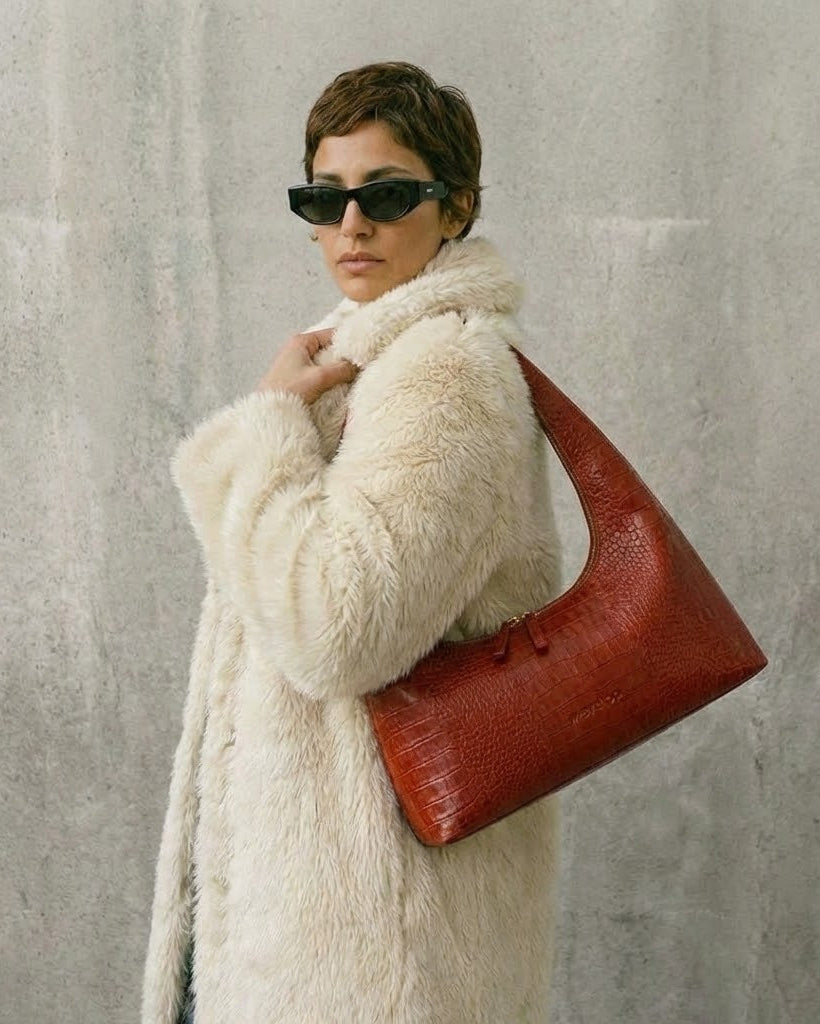 Red croco hobo bag worn on model with creme fur coat